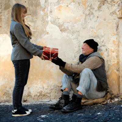 woman giving homeless man a gift