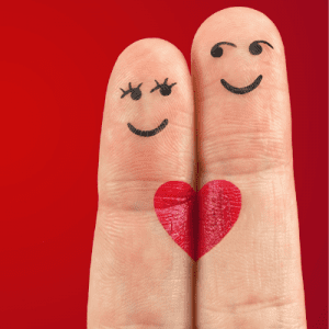 Two fingers with happy faces and red heart drawn on them